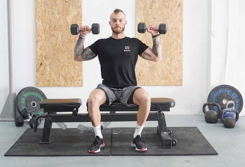 man seated shoulder press dumbbell