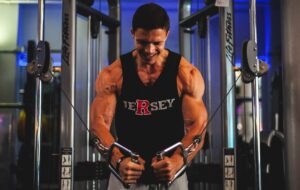 a muscular man performing chest fly on a double cable machine in a gym setting